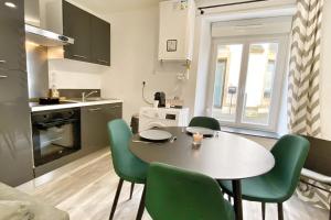 cocina con mesa y sillas verdes en una habitación en Le Petit Frontalier - A FERMER, en Terville