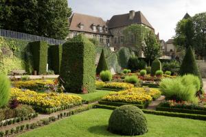 un jardín con arbustos y flores frente a un edificio en LD-Location Montluçon Intermarché en Montluçon