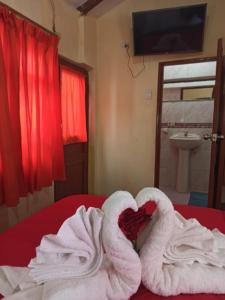 una camera d'albergo con asciugamani e un cuore su un letto di Hostal Tu Hogar a Cuzco