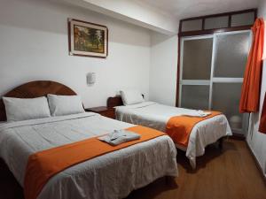 una camera d'albergo con due letti e una finestra di Hostal Tu Hogar a Cuzco