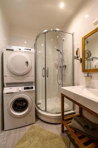 a bathroom with a shower and a washing machine at Liepaja Apartments Downtown in Liepāja