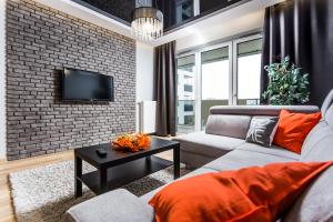 a living room with a couch and a brick wall at ResiNest Apartamenty Jurowiecka J19 in Białystok