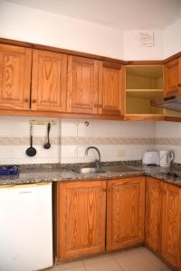 a kitchen with wooden cabinets and a sink at Sunny Silencio Park in Arona