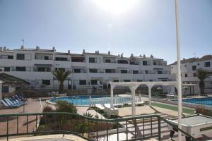 a large white building with a swimming pool and a resort at Sunny Silencio Park in Arona
