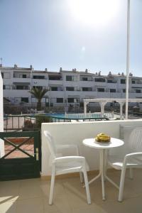a white table and chairs on a balcony with a building at Sunny Silencio Park in Arona