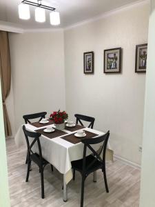 a dining room with a table and four chairs at Apartment Батыс 2, 44 in Aktobe