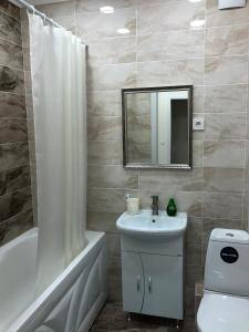 a bathroom with a sink and a toilet and a mirror at Apartment Батыс 2, 44 in Aktobe