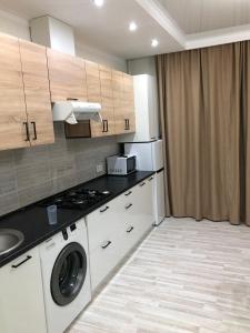 a kitchen with a washer and dryer in a room at Apartment Батыс 2, 44 in Aktobe