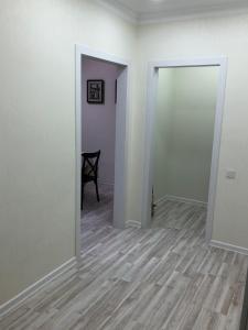 an empty room with an open door and a chair at Apartment Батыс 2, 44 in Aktobe