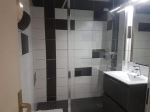 y baño con lavabo y ducha con espejo. en Logis Hotel Des Grands Vins, en Fleurie