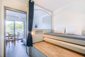 a small bedroom with a bed and a dining room at Hyères Parc- Vue mer Méditterannée in Hyères