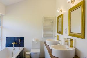 ein Badezimmer mit zwei Waschbecken und einer Toilette und einem Spiegel in der Unterkunft Beach House DeLuxe in Glória + 63 Fotos