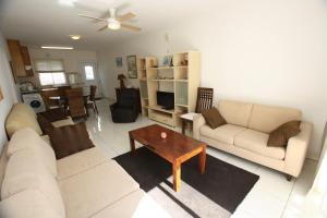 a living room with two couches and a coffee table at Pissouri Beach Apartments in Pissouri