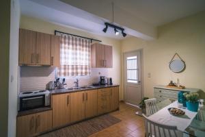 a kitchen with wooden cabinets and a table and a sink at Penny's Apartment in Exámbela