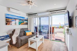 a living room with a couch and a view of the ocean at Marlin II Puerto del Carmen in Puerto del Carmen