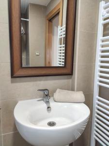 y baño con lavabo blanco y espejo. en Apartamento La Añaza en Villanúa