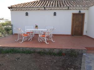 a patio with a table and chairs and a house at El Regalo de mis Abuelos in Santa Lucía