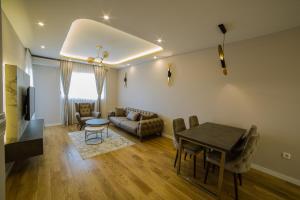 een woonkamer met een tafel en een bank bij Apartments Centrale 28 in Podgorica