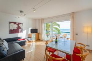 a living room with a couch and a table with chairs at InSitges Sant Sebastia's Beach in Sitges