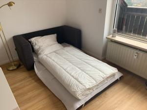 un lit avec une tête de lit noire dans une chambre dans l'établissement Gemütliche Ferienwohnung Harz Braunlage Hohegeiß, à Braunlage