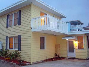 ein gelbes Haus mit einer Terrasse und einem Balkon in der Unterkunft Tybeeland Steps to the Beach with Oceanviews, Beachside of Butler Ave in Tybee Island