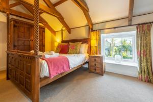 a bedroom with a wooden bed and a window at Sunflower Cottage - Gonwin Manor in Carbis Bay