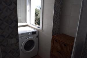 uma máquina de lavar roupa na casa de banho com uma janela em La Dimora di Lalla em Lanciano