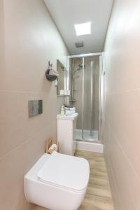 een witte badkamer met een toilet en een douche bij Willa Biały Domek in Ustroń