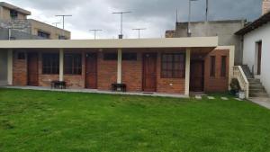 ein Gebäude mit grünem Rasen davor in der Unterkunft Villa Victoria in Machachi