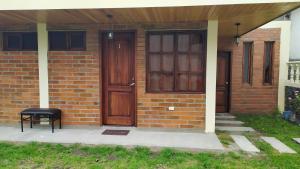 a brick house with two wooden doors and a stool at Villa Victoria in Machachi