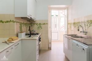 a white kitchen with a sink and a counter at Casa da Avenida Lisboa in Lisbon