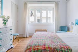 a white bedroom with a bed and a window at Casa da Avenida Lisboa in Lisbon