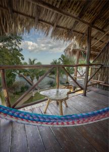 a porch with a hammock and a table on a deck at Amigos Hotelito in Bacalar