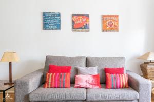 a gray couch with colorful pillows in a living room at Casa da Avenida Lisboa in Lisbon