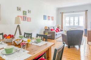 a dining room and living room with a table and chairs at Casa da Avenida Lisboa in Lisbon