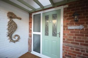 a front door of a house with a seahorse on the wall at Lakeside Old Hunstanton in Hunstanton