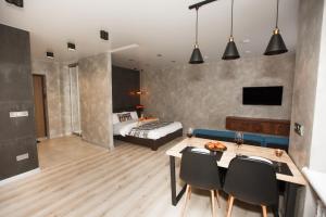 a living room with a dining table and a bedroom at Style Стильні апартаменти в ЖК "Варшавський" біля парку in Ternopilʼ
