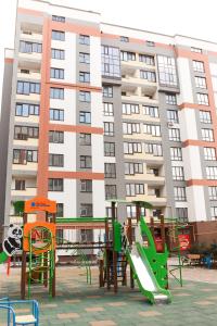 a playground in front of a large building at Style Стильні апартаменти в ЖК "Варшавський" біля парку in Ternopilʼ