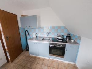 a small kitchen with a sink and a stove at Pension Dalina in Sagard