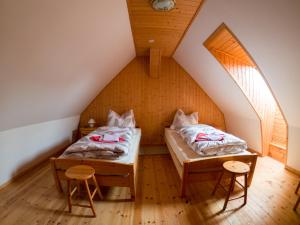 a attic room with two beds and two stools at Pension Dalina in Sagard