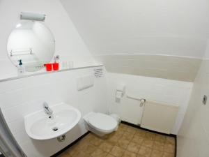 a white bathroom with a toilet and a sink at Pension Dalina in Sagard