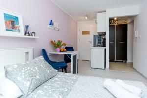 a bedroom with a bed and a table and a kitchen at RentApart Stare Miasto in Gdańsk