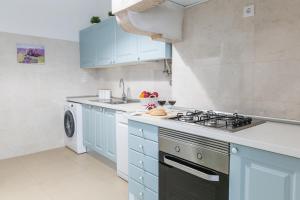 a kitchen with blue cabinets and a stove at Casa da Avenida Lisboa in Lisbon