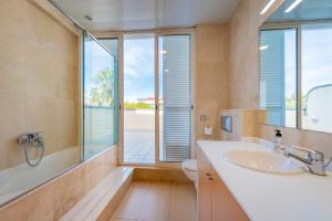 baño con lavabo y aseo y ventana en InSitges Sant Sebastia's Beach, en Sitges