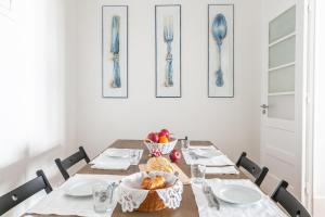 a dining room table with a basket of fruit on it at Casa da Avenida Lisboa in Lisbon