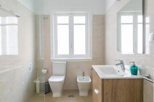 a white bathroom with a toilet and a sink at Casa da Avenida Lisboa in Lisbon