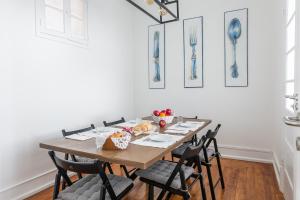 a dining room with a wooden table and chairs at Casa da Avenida Lisboa in Lisbon