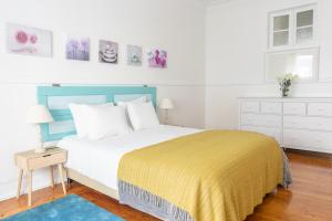 Casa da Avenida Lisboa في لشبونة: غرفة نوم بسرير كبير مع بطانية صفراء