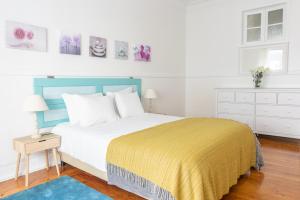 a bedroom with a large bed with a yellow blanket at Casa da Avenida Lisboa in Lisbon