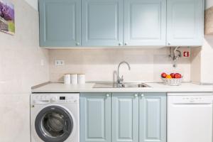 a kitchen with a sink and a washing machine at Casa da Avenida Lisboa in Lisbon